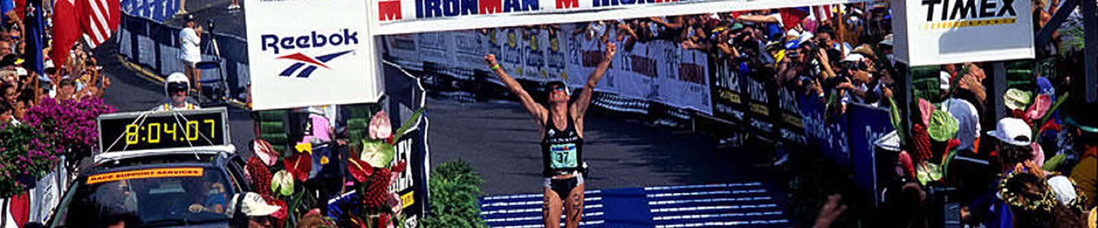 Luc Van Lierde winning the Ironman with arms raised at the finish line
